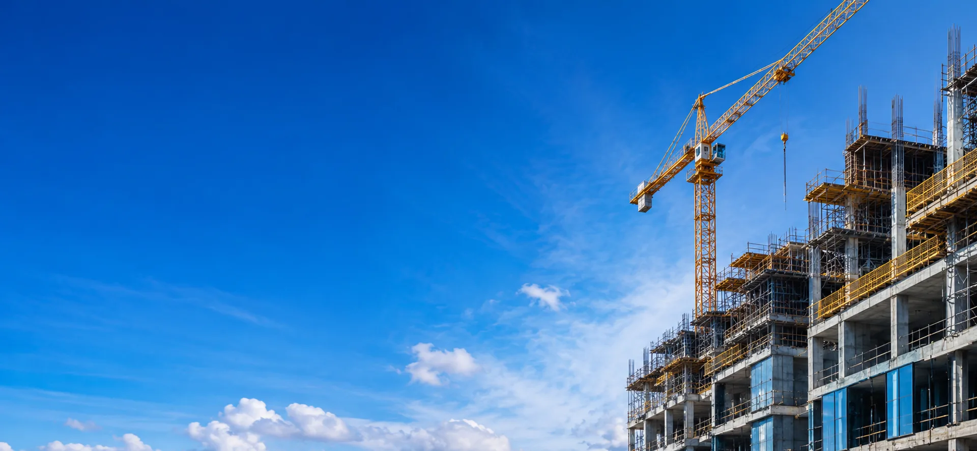 Tower crane over a high-rise structure under construction against a clear sky